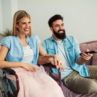 Handicapped,Woman,And,Her,Husband,Watching,Tv,Together